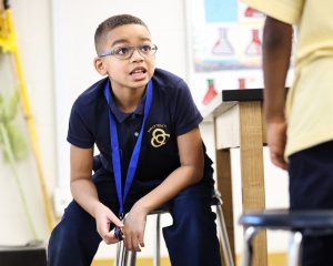 Holy Trinity student talking to fellow student in class.